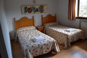 um quarto com 2 camas e uma janela em Hotel Rural Marcos em Rascafría