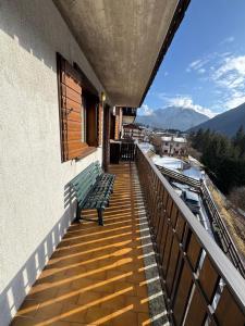a balcony with a bench and a view of the mountains at Casa Gatto in Auronzo di Cadore