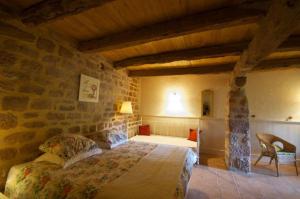 1 dormitorio con 1 cama en una pared de piedra en Château Labistoul en Campes