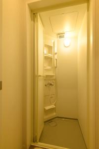 a small bathroom with a refrigerator and a light at Guesthouse Nagonde in Kanazawa +47 photos