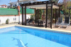 a swimming pool with a gazebo and a table and chairs at Studio Tropical in Cúllar-Vega