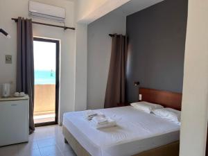 sypialnia z łóżkiem i widokiem na plażę w obiekcie Kalami Rooms w mieście Falasarna