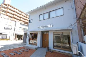 a large white building with a sign on it at Guesthouse Nagonde in Kanazawa