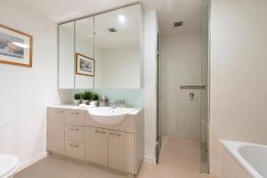 a white bathroom with a sink and a shower at Docklands Private Collection - NEWQUAY in Melbourne
