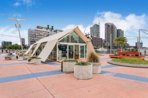 a building with a triangular roof in a city at Docklands Private Collection - NEWQUAY in Melbourne