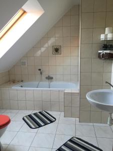 a bathroom with a bath tub and a sink at Pensjonat u Alexa in Załuski