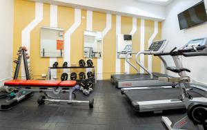 a gym with treadmills and machines in a room at Cozy 1 Studio Room - The Residences BGC Taguig in Manila
