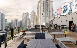 a balcony with tables and chairs and a city skyline at Cozy 1 Studio Room - The Residences BGC Taguig in Manila