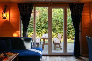 a living room with a couch and a sliding glass door at Domek Zalesie in Barczewo
