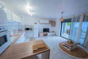 a large white kitchen with a table and a large window at Sea View & Spa privé La Possession in La Possession