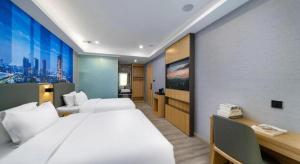 Postel nebo postele na pokoji v ubytování Sheng Lin Na Hotel Minzhi Branch