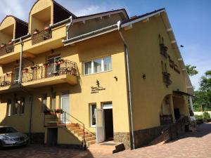 a yellow building with balconies and a car parked outside at Casa Veronica in Baile Felix