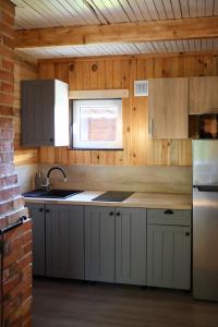 a kitchen with white cabinets and a sink and a window at Domek Zalesie in Barczewo +29 photos