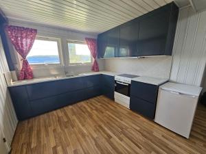cocina con armarios azules y suelo de madera en Leilighet i Holmestrand, en Holmestrand