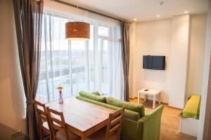 ein Wohnzimmer mit Tisch und großem Fenster in der Unterkunft Sky Studio near the Vilnius Center in Vilnius
