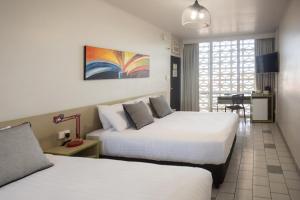 una camera d'albergo con due letti e un tavolo di Nightcap at Emerald Star Hotel a Emerald