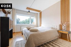 a bedroom with a large bed and a window at Seaside new home with sunny balcony in Pärnu