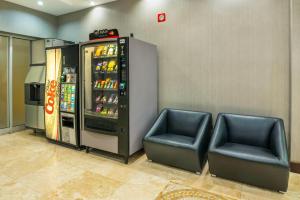 a soda machine with two chairs in a room at Comfort Inn & Conference Centre Toronto Airport in Toronto