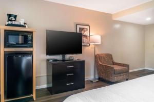 a hotel room with a flat screen tv and a chair at Best Western River Terrace in Cheboygan