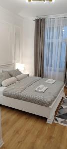 a white bed in a room with a window at Bulevar Mostar Old Bridge in Mostar