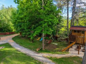 a playground with a tree and a slide at Tesla`s Valley in Smiljan