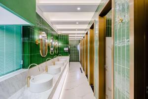 a bathroom with four sinks and green tiles at Eastern Paris Girls' Youth Hotel in Shanghai
