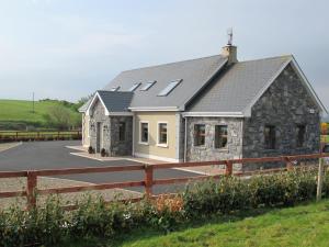 a home with a stone house with a fence at O'Learys Lodge in Doolin