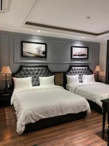 a bedroom with two beds and two pictures on the wall at Malisa Hotel in Như Thức