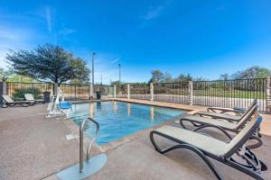 una piscina con sedie a sdraio accanto a una recinzione di Best Western La Grange Inn & Suites a La Grange