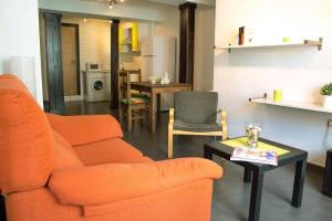 sala de estar con sofá naranja y mesa en Apartamento Senderos de Hervas, en Hervás