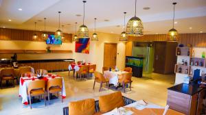 a dining room with tables and chairs in a restaurant at Millennium Terrace Hotel in Kampala