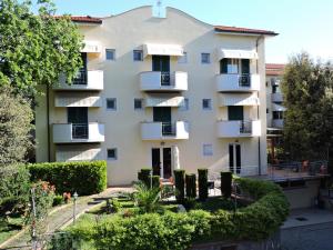 un gran edificio de apartamentos con balcones y arbustos en Hotel Il Pino, en San Vincenzo