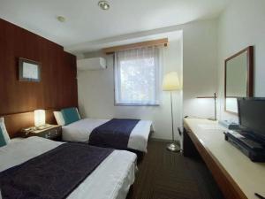 une chambre d'hôtel avec deux lits et une télévision à écran plat dans l'établissement Fujino Kinjo, à Shimo-yoshida 178 autres photos