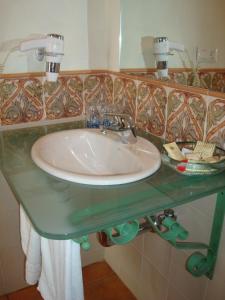 a bathroom sink with a glass counter and a mirror at Almadraba Conil in Conil de la Frontera