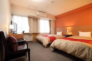 2 Betten in einem Hotelzimmer mit orangefarbenen Wänden in der Unterkunft Hotel 1-2-3 Kofu Shingen Onsen in Showa + 179 Fotos