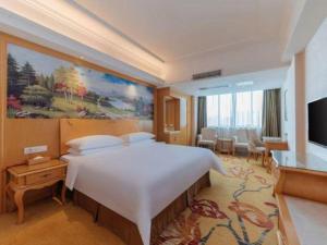 a hotel room with a large bed and a television at Vienna Hotel Guangdong Qingyuan Wanda Plaza Xincheng Beijiang in Qingyuan +205 photos