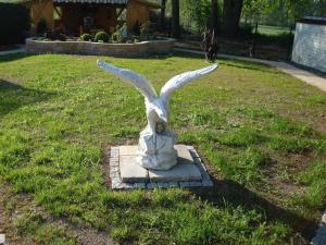 a statue of a bird sitting in the grass at Pension-Eula in Borna