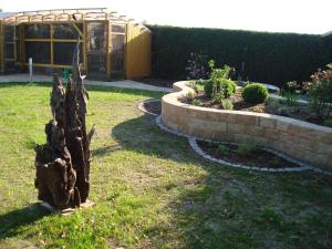 a garden with a tree stump in the grass at Pension-Eula in Borna