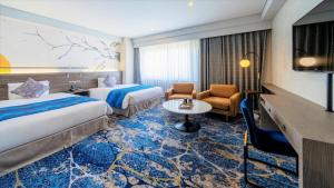 a hotel room with two beds and a table at KKR Hotel Hakata in Susakiuramachi +125 photos