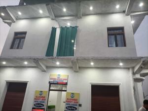 a building with green curtains on the side of it at Hotel O by OYO Allahabad Property in Bhīta