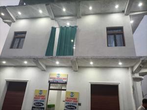 a building with green curtains on the side of it at Hotel O by OYO Allahabad Property in Bhīta