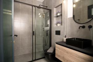 a bathroom with a glass shower and a sink at DG space 1A in Kalamata