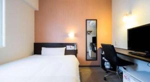 a bedroom with a bed and a desk and a television at Super Hotel Hofu-Ekimae in Yamaguchi