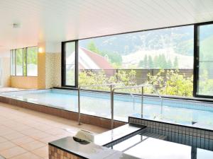 富山Tateyama Kokusai Hotel的一座大型游泳池,位于一座带大窗户的建筑内