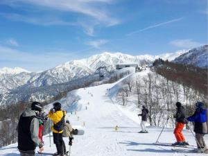 富山Tateyama Kokusai Hotel的一群站在滑雪场顶端的人