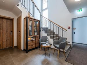 przedpokój z 2 krzesłami, stołem i schodami w obiekcie Luxury Chalet in Saalbach-Hinterglemm with Sauna w Saalbach Hinterglemm