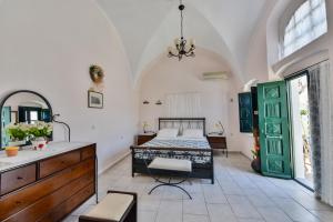 a room with a bed, a table and a window at Christos Apartments Oia in Oia