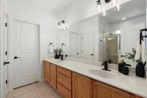 Un baño blanco con lavabo y espejo. en New! Relaxing Boho Pines Haven Flagstaff! HotTub, BBQ, GameRm, en Flagstaff 19 fotos más