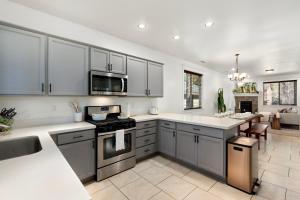 Una cocina con gabinetes grises y encimeras blancas. en New! Relaxing Boho Pines Haven Flagstaff! HotTub, BBQ, GameRm, en Flagstaff