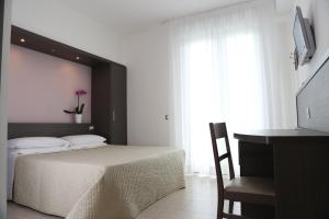 Un pat sau paturi într-o cameră la Hotel Beatrice
